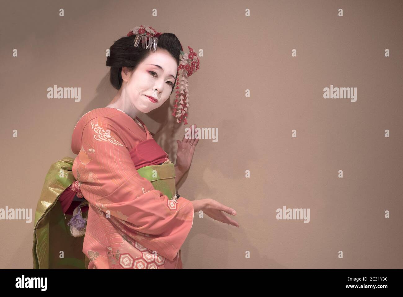 Clipping japanese geisha maiko girl in red kimono coifed hair brooch with patterns of red and white Stock Photo