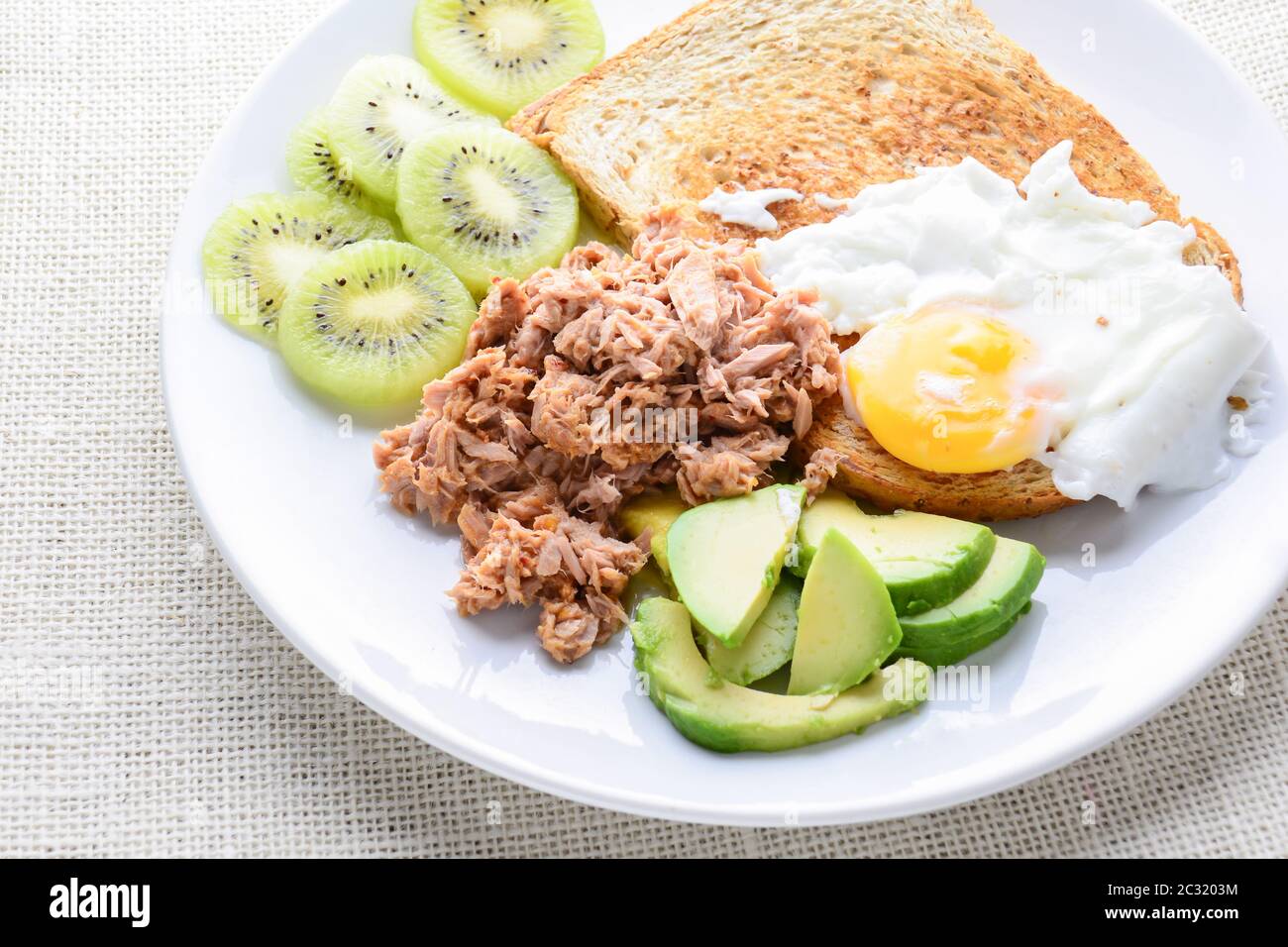 Modern style clean food, bread, egg, tuna salad, kiwi and avocado Stock Photo