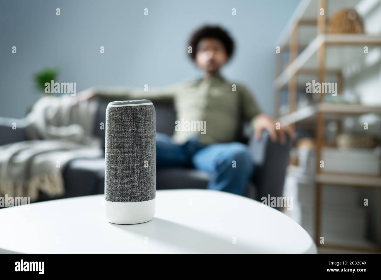 Young Man Using Wireless Speaker At Home Stock Photo