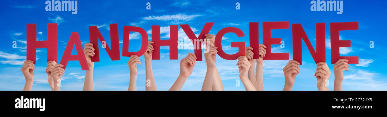 People Hands Holding Red German Word Handhygiene Means Hand Hygiene. Blue Sky As Background Stock Photo