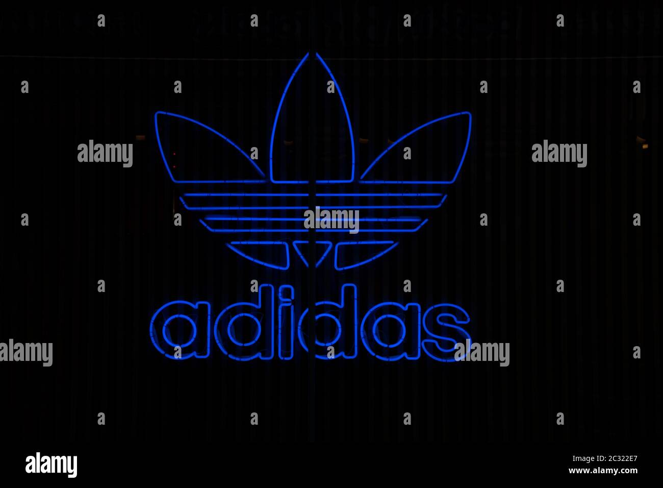 Adidas Originals neon light logo. Black background Stock Photo -