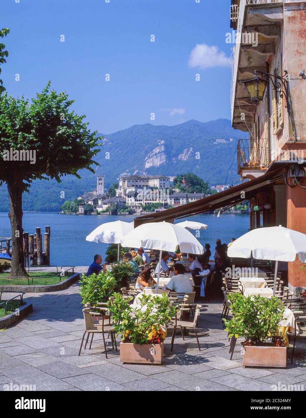 Lakeside restaurant with Isola San Giulio behind, Orta San Giulio, Province of Novara, Piemonte (Piedmont) Region, Italy Stock Photo