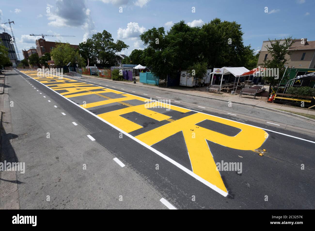 Austin, TX USA June 18, 2020: City of Austin yellow letters spelling 'Black Artists Matter' are painted in the historically black neighborhood of East 11th Street in Austin after a coalition of artists and activists finished the mural. The painting came two days after the same group painted 'Black Austin Matters' on Austin's Main Street, Congress Avenue.Credit: ATXN via Bob Daemmrich/Alamy Live News Stock Photo