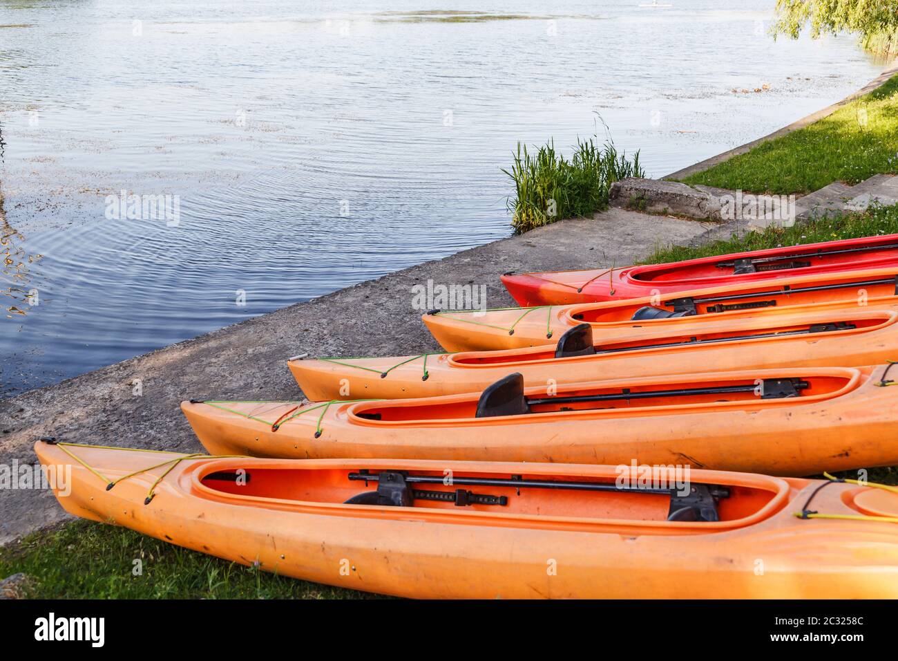 Polymer kayaks, water sports. Canoe summer club equipment. Active rest, sport, kayak. Boat for rafting on water. A few kayaks stand on rent point Stock Photo