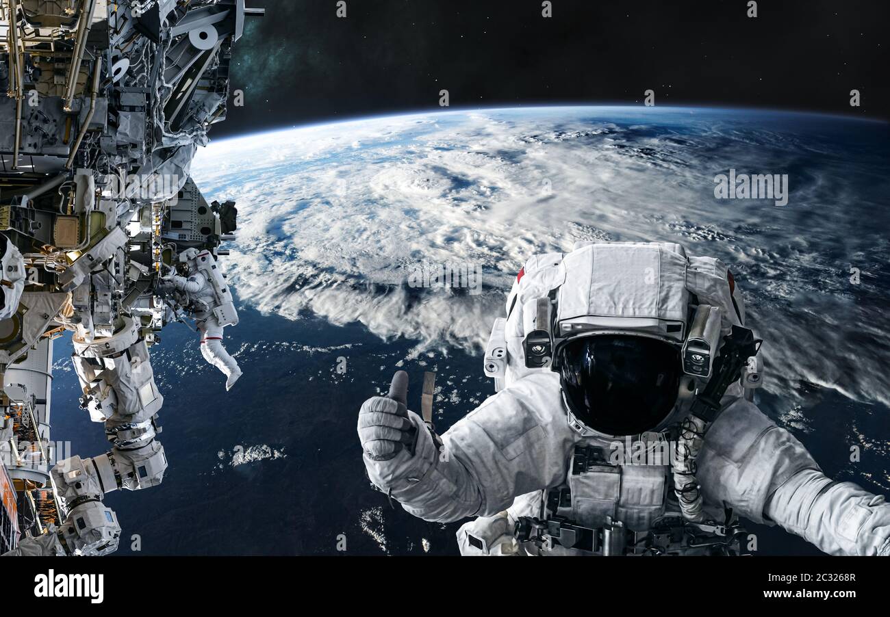Astronauts and the ISS in orbit of the planet Earth. Solar system Stock  Photo - Alamy