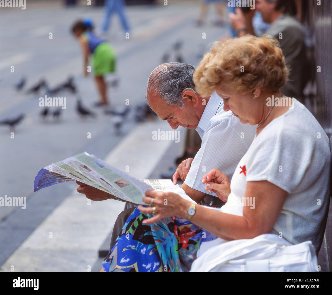 Older couple looking at city map, Piazza del Duomo, Milano (Milan), Lombardy Region, Italy Stock Photo