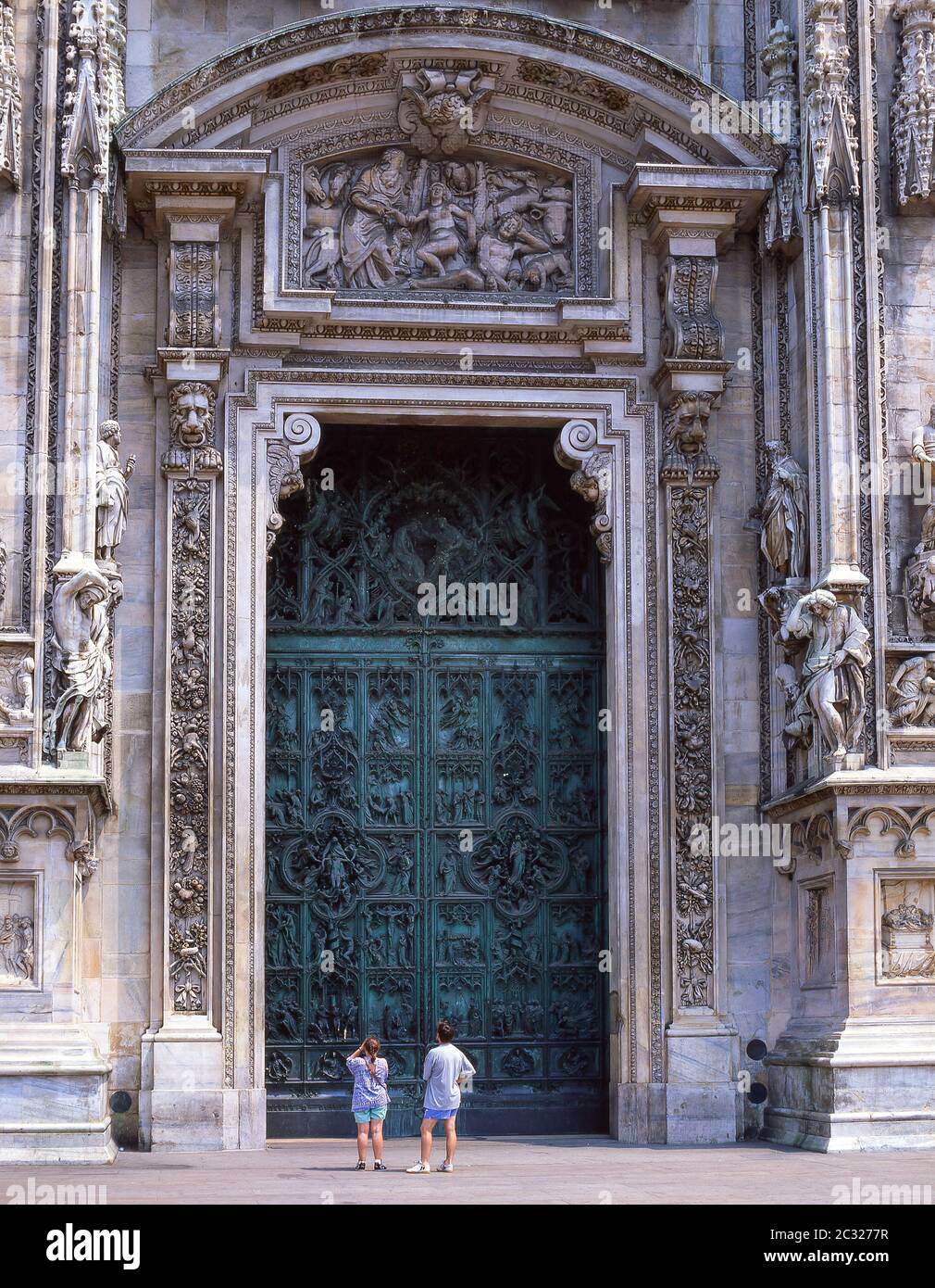 Bronze central door on facade of Duomo di Milano (Milan Cathedral), Piazza del Duomo, Milano (Milan), Lombardy Region, Italy Stock Photo
