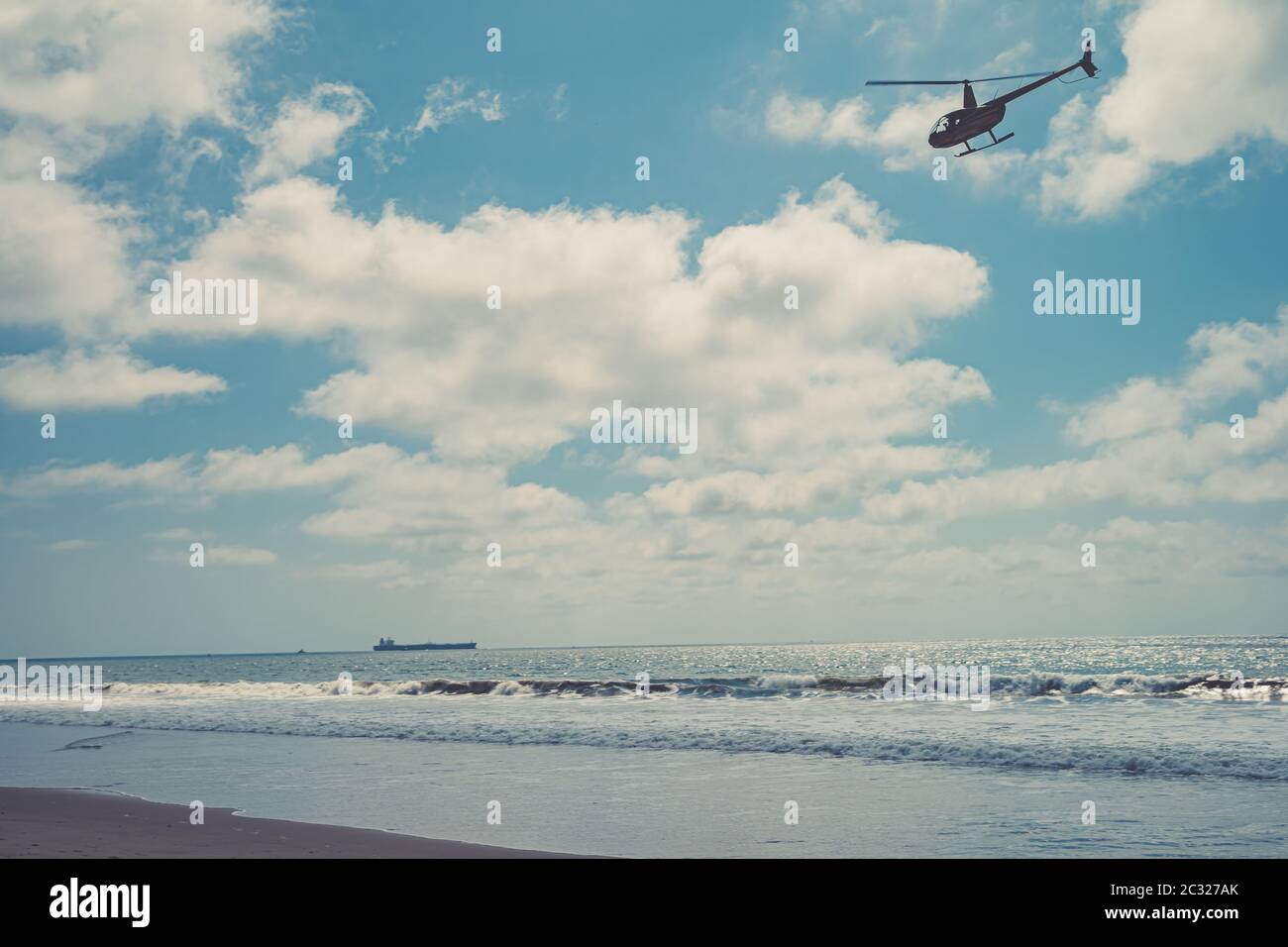 Helicopter patrols over the sea beach Stock Photo - Alamy