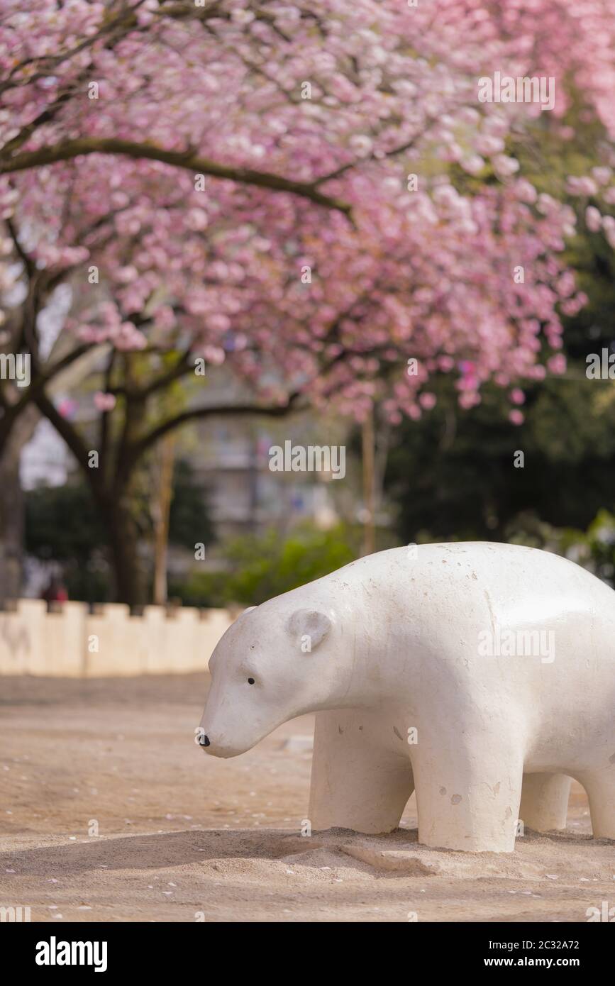 Cute white bear sculpture under the cherry blossoms of Asukayama Park in the Kita district Stock Photo
