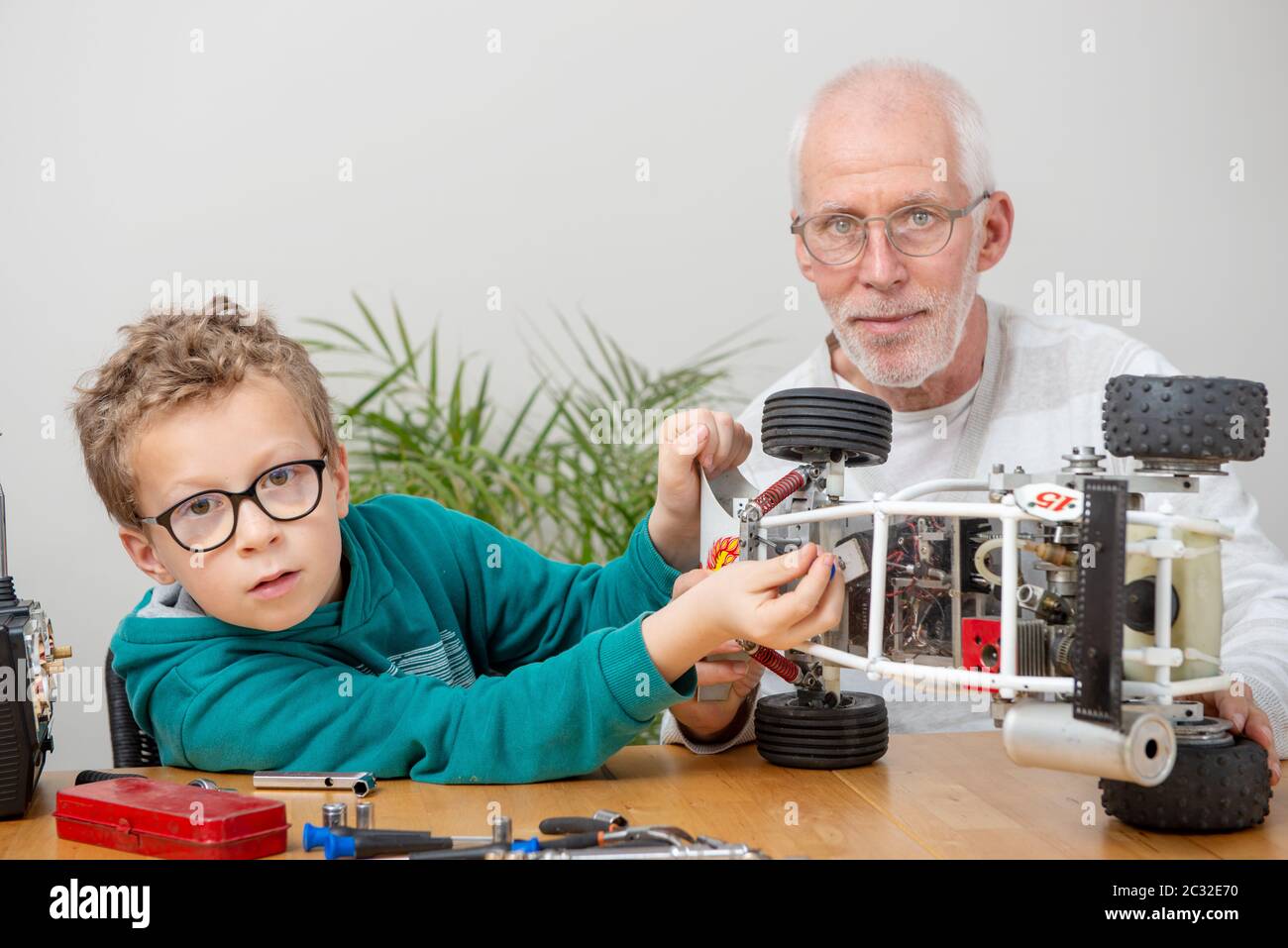 grandpa and son little boy repairing a  model radio-controlled car at home Stock Photo