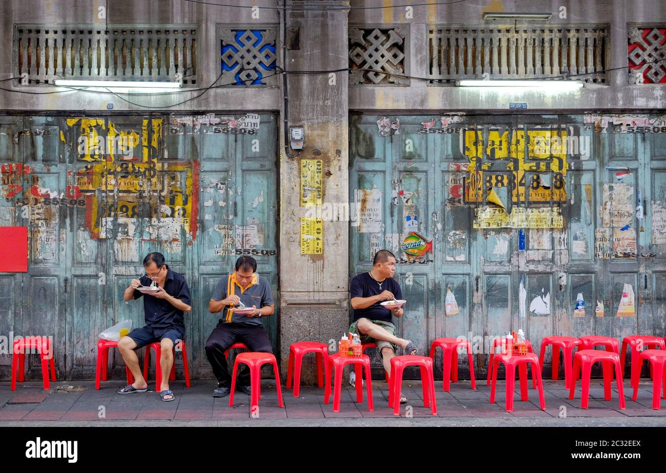 Bangkok-Thailand JUL 6 2017: Unidentified Thai Asian people who' re sit on red chair for eating curry rice street food on footpath at Chinatown Stock Photo