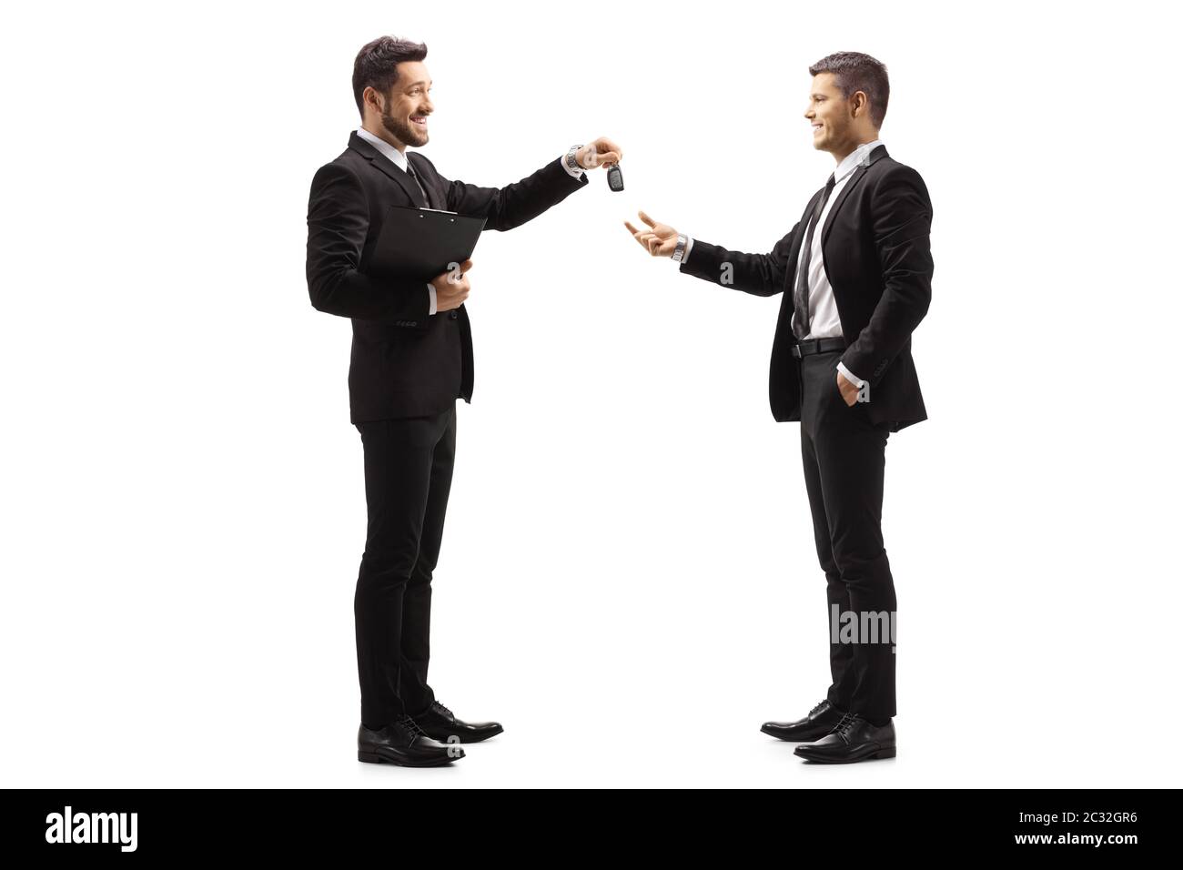 Full length profile shot of a businessman giving car keys to a man isolated on white background Stock Photo