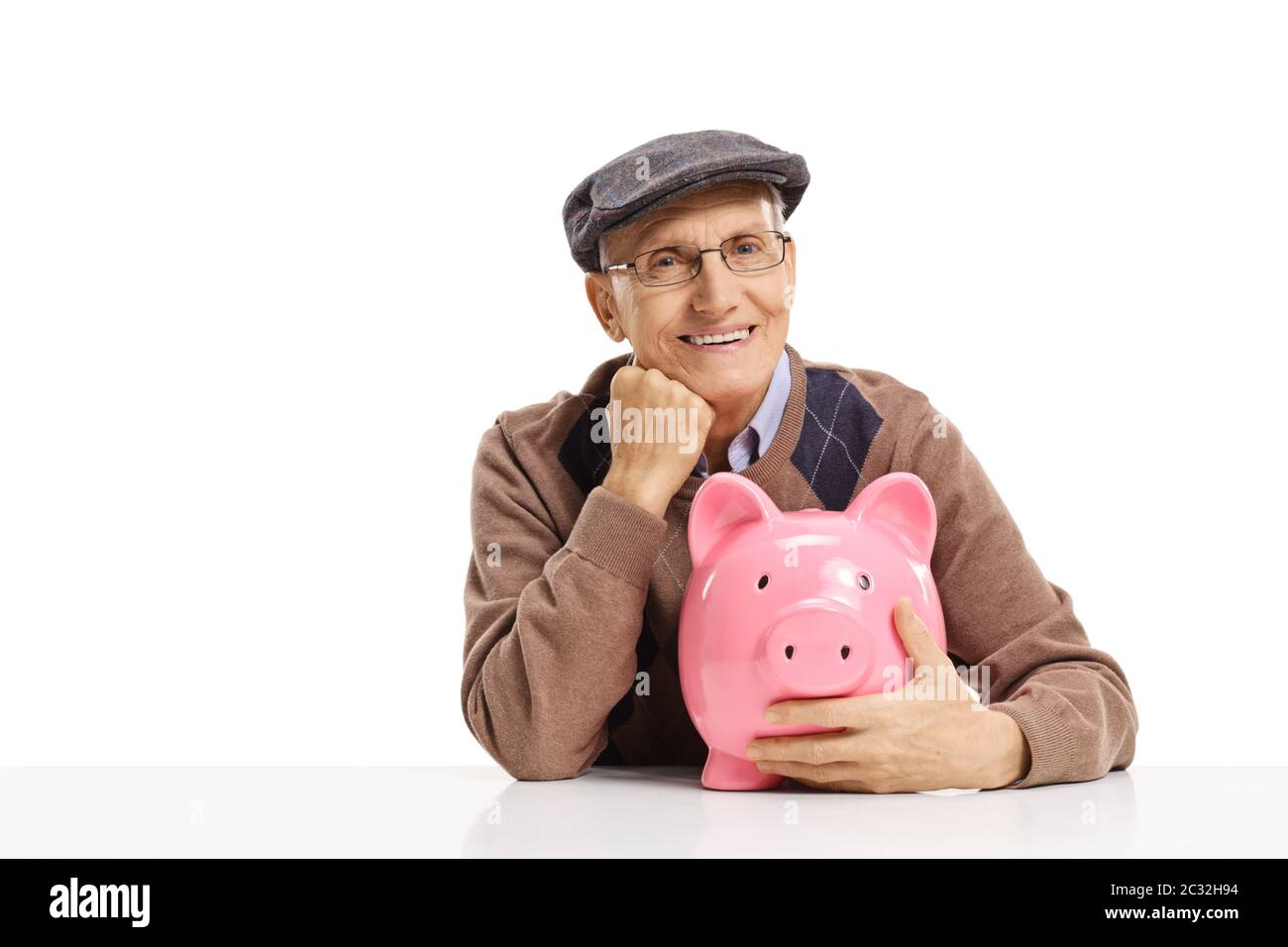 Happy elderly man sitting and hugging a pink piggy bank isolated on ...