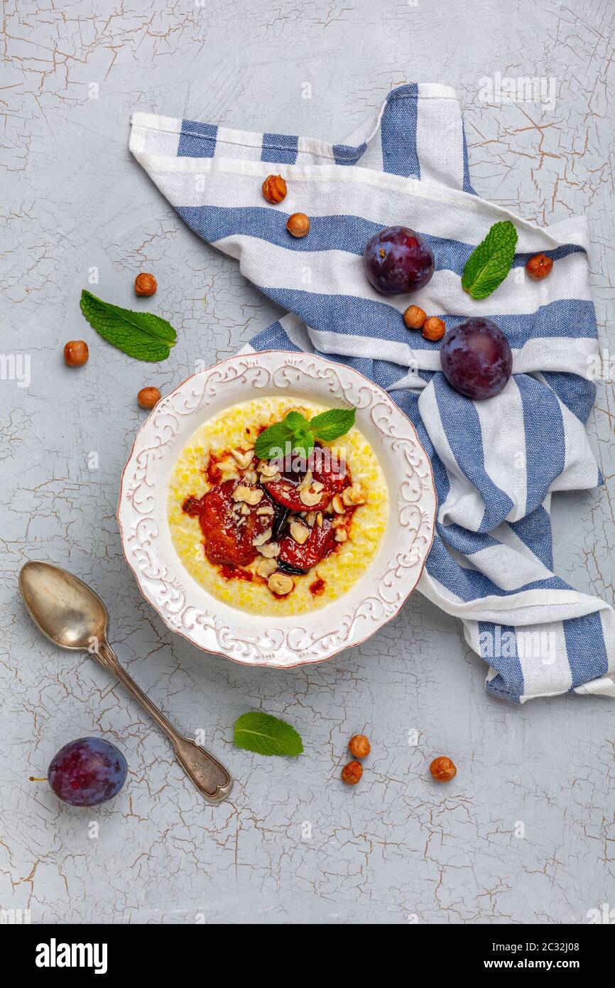 Millet porridge with caramelized plum and hazelnuts. Stock Photo
