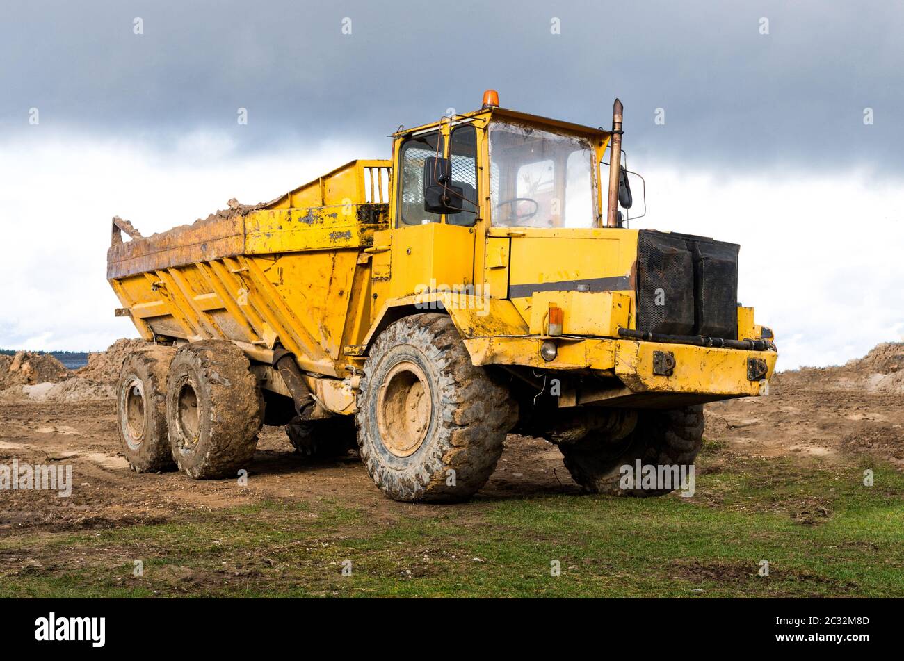 The big dump truck stay on the field. Stock Photo