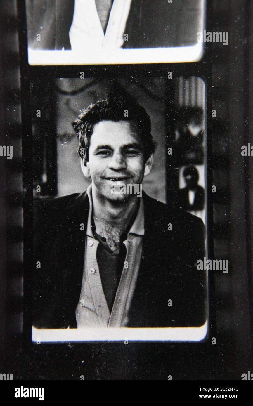 Fine 70s vintage contact print black and white extreme photography of a likeable thirtysomething man looking at the camera and posing for a portrait. Stock Photo