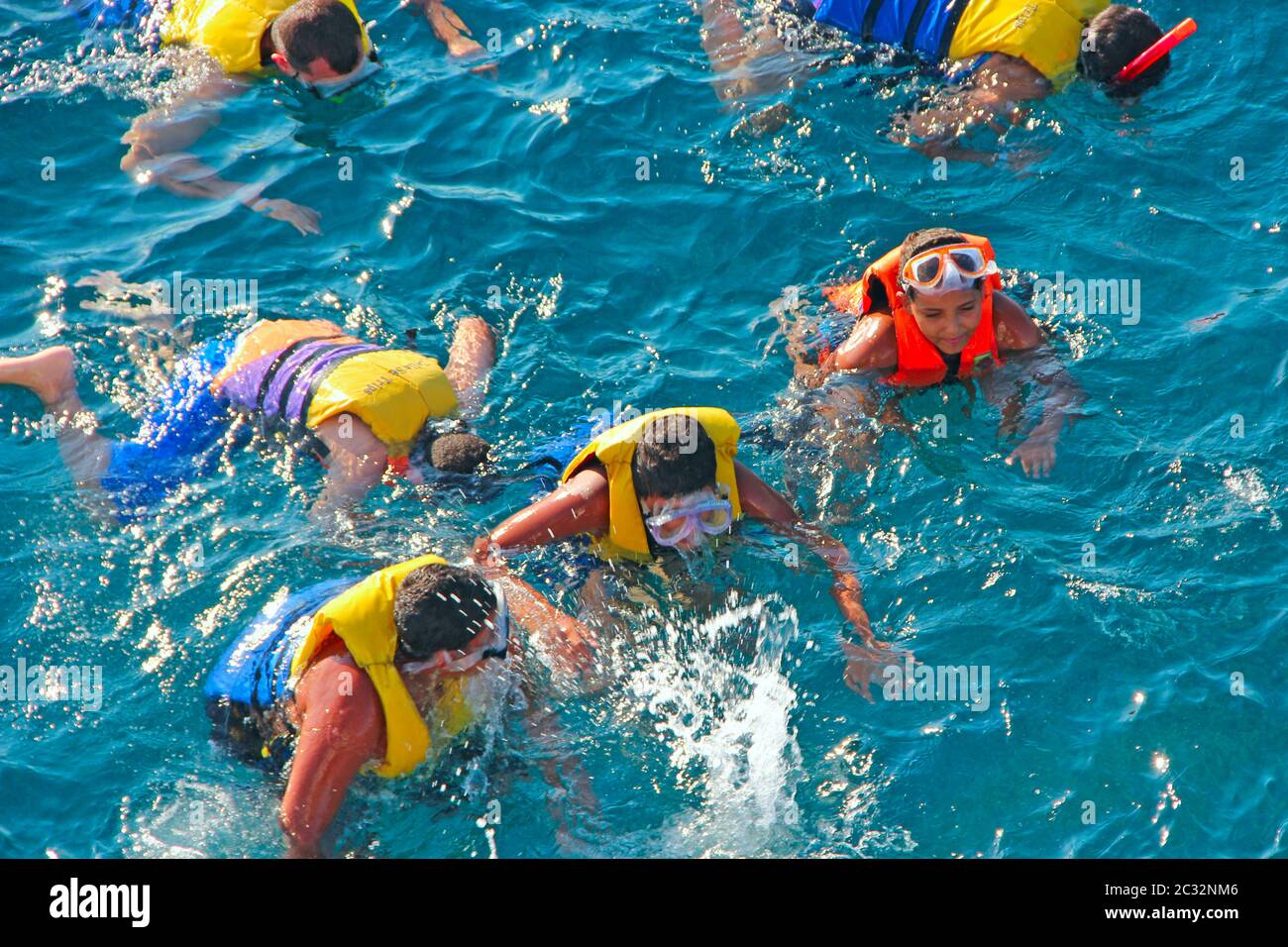 People diving in sea with masks and life jackets Stock Photo