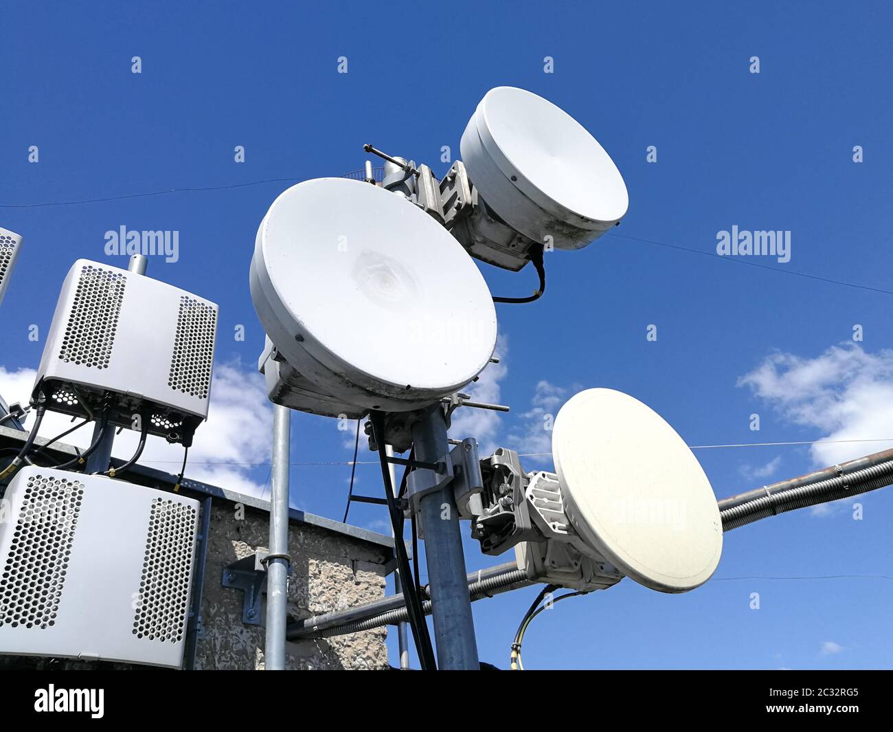 GSM (Global System for Mobile communication) base station and repeater  tower in front of blue cloudy sky for telecommunications Stock Photo - Alamy