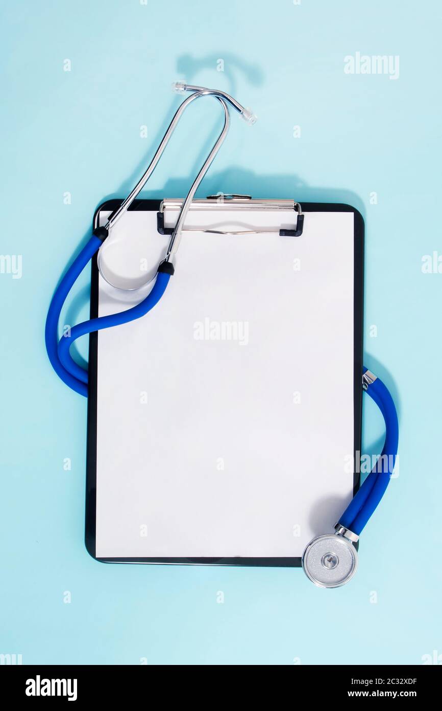 Medical clipboard and a stethoscope isolated on a light blue background ...