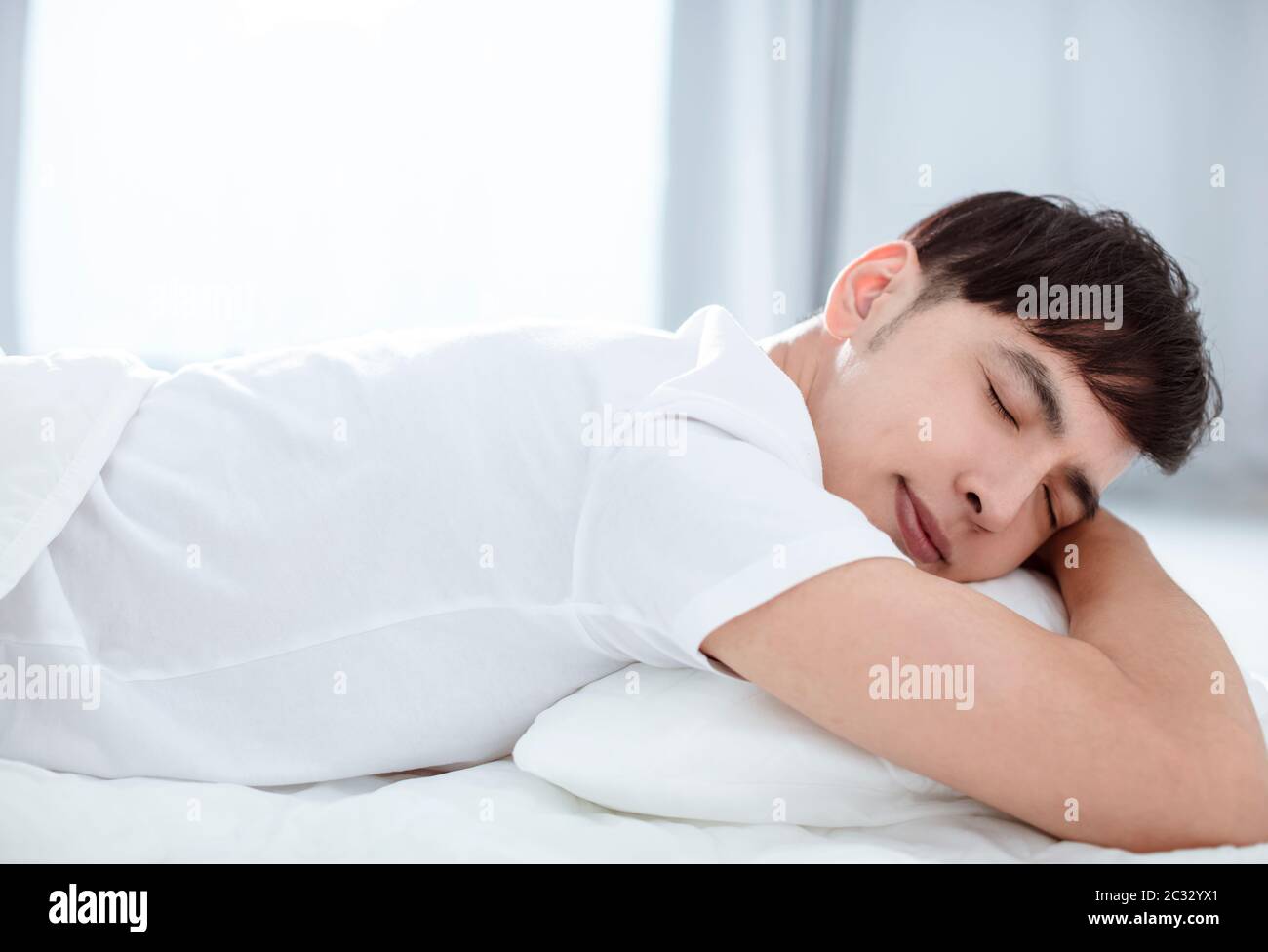Handsome young man sleeping in bed Stock Photo