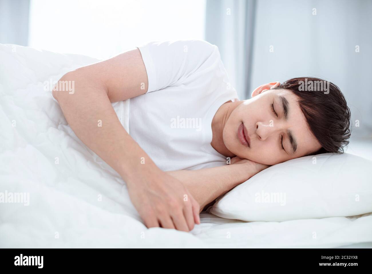 Handsome young man sleeping in bed Stock Photo
