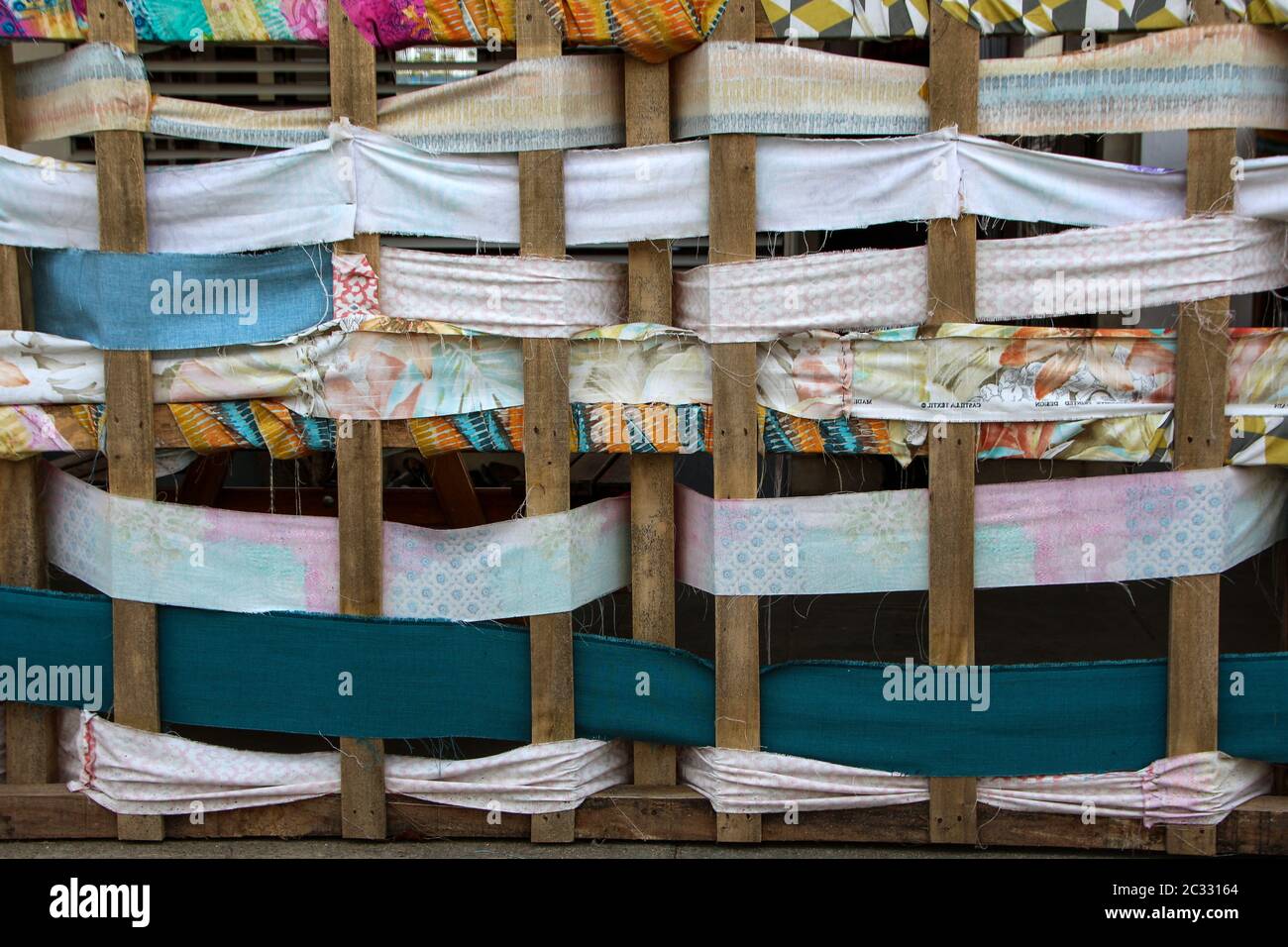 Close up view of colorful woven fabric between wood Stock Photo - Alamy
