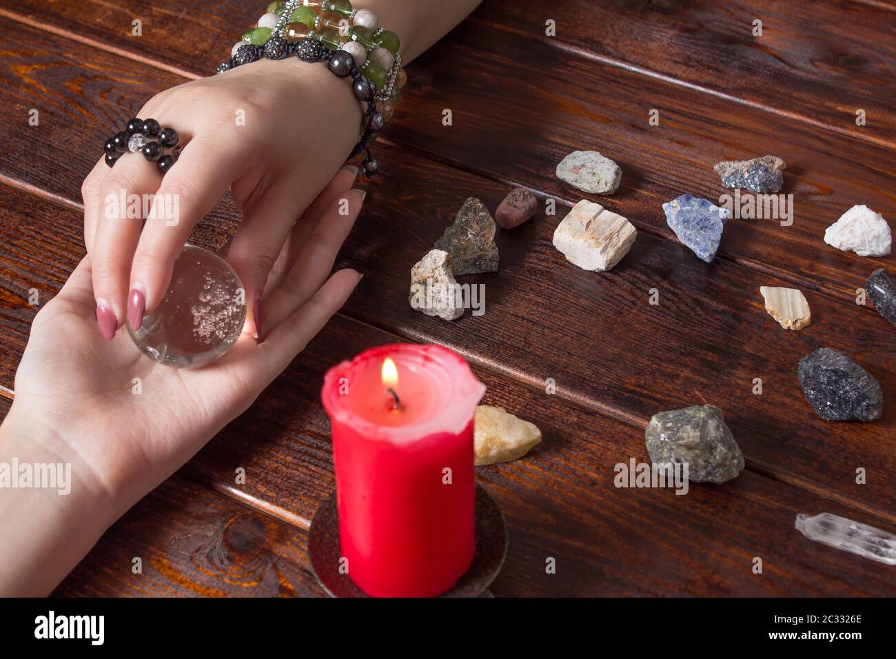 Fortune teller predicts fate using a magic ball, stones and a lit