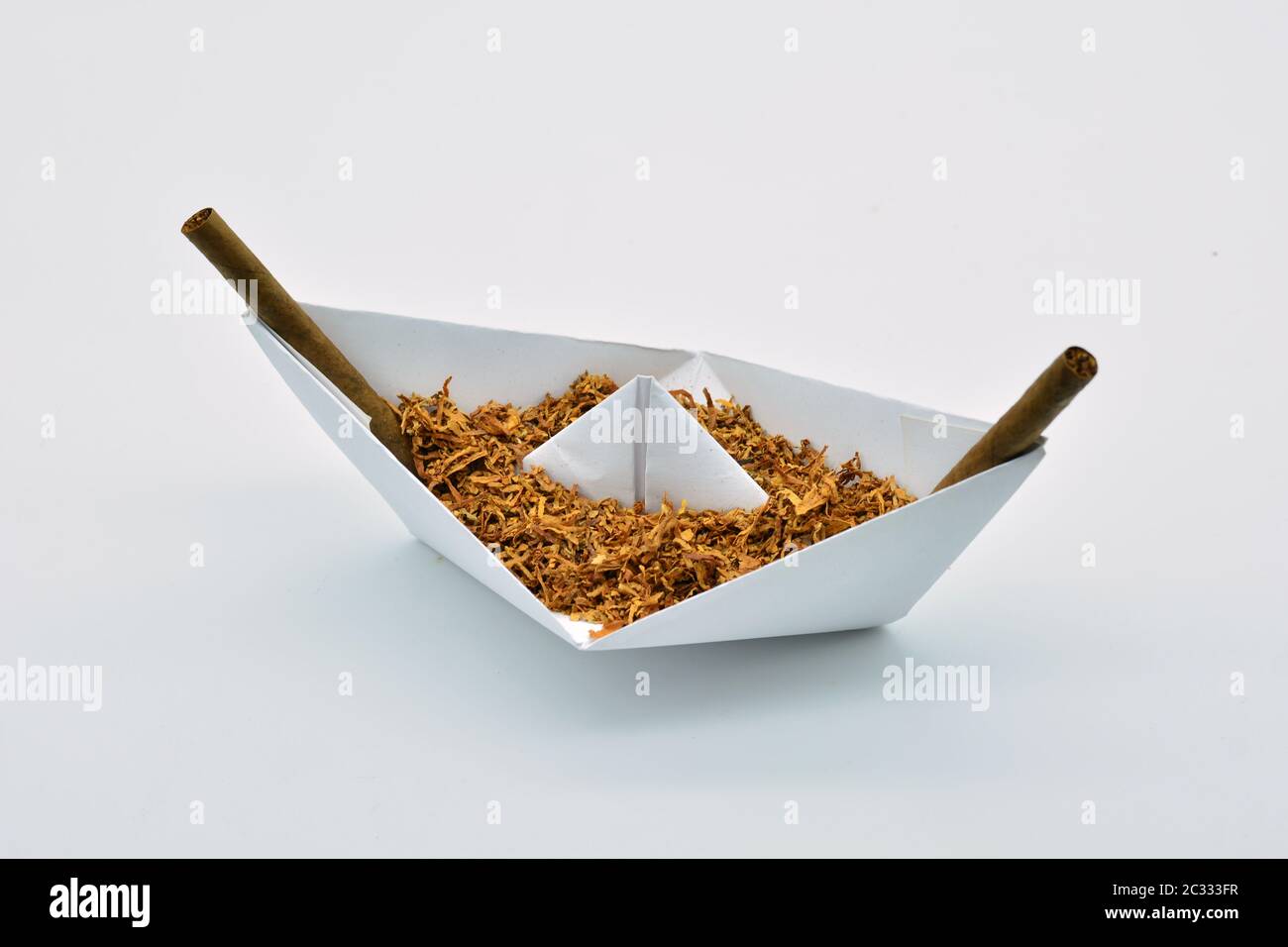 Barco de papel cargado de tabaco sobre fondo blanco Stock Photo