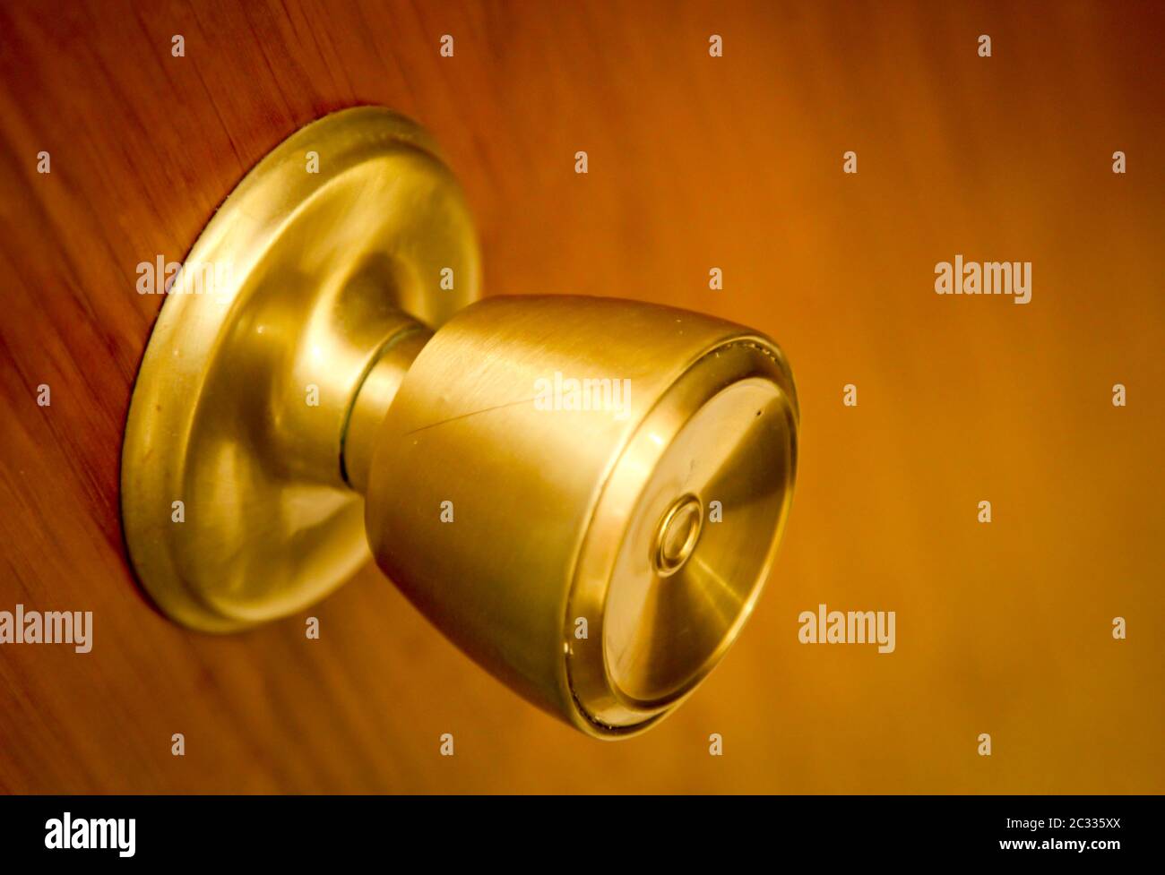 Golden, brass colored door opener, latch on a wooden door Stock Photo