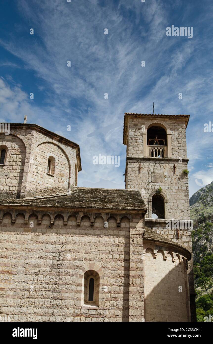 Old stone church and bell tower under blue sky in Kotor, Montenegro ...