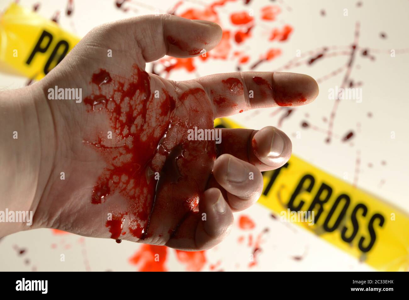 Closeup of a victim at a crime scene with bloody hands. Stock Photo