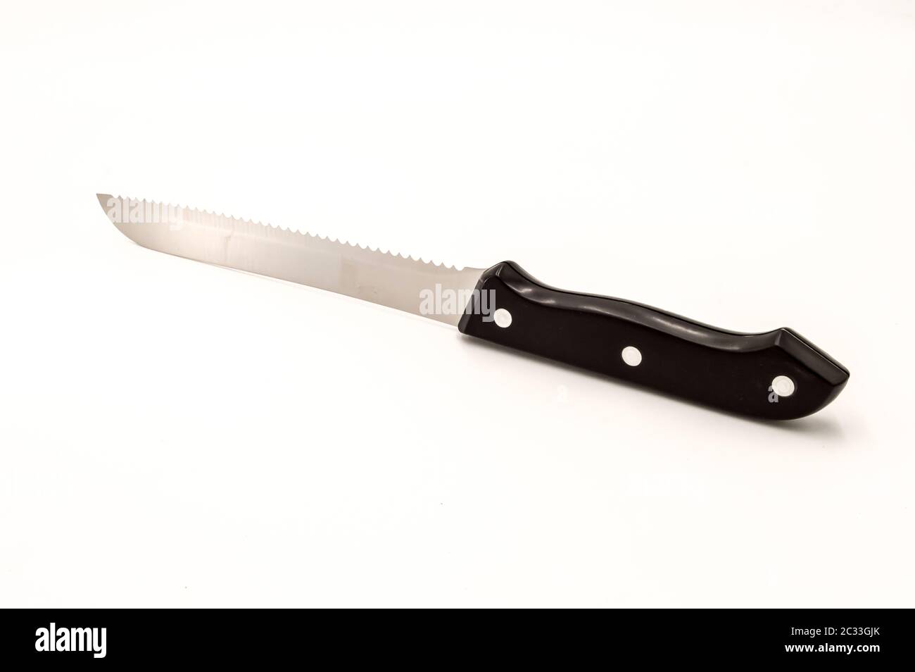 Chromium sawtooth knife with a black handle on a white background Stock