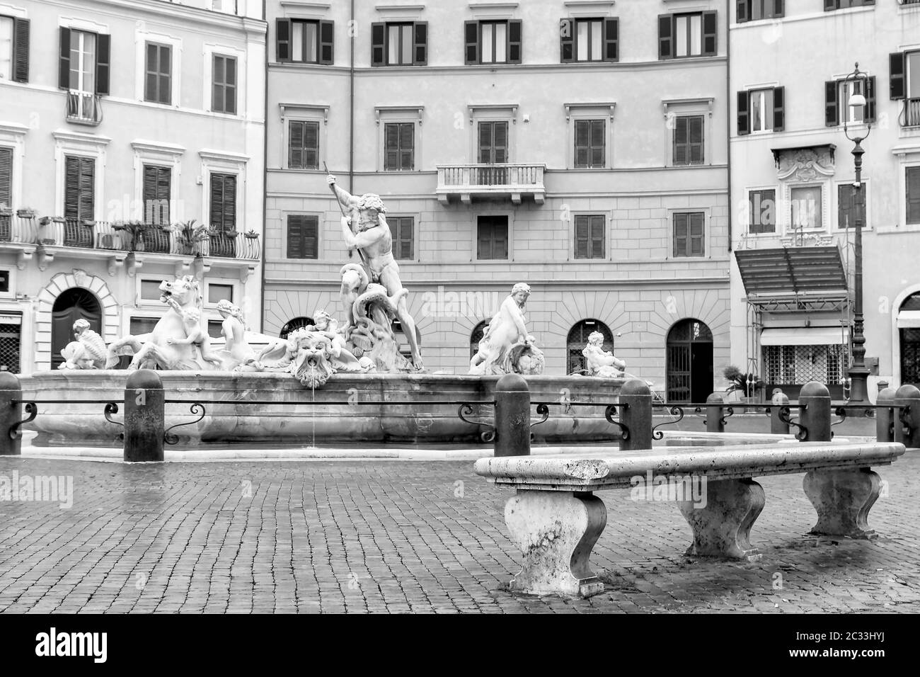 Black and white photo of the empty stone bench in front of the Fountain of Neptune located at the Square Navona (Piazza Navona) in Rome. Italy. All po Stock Photo