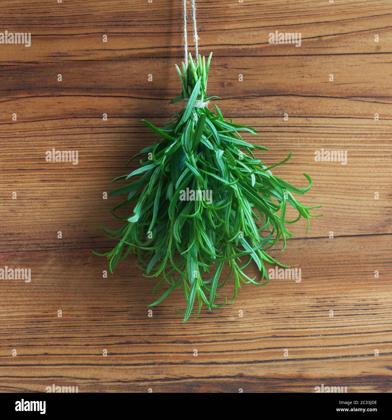 A Bunch Of Rosemary In Front Of A Wooden Background Stock Photo