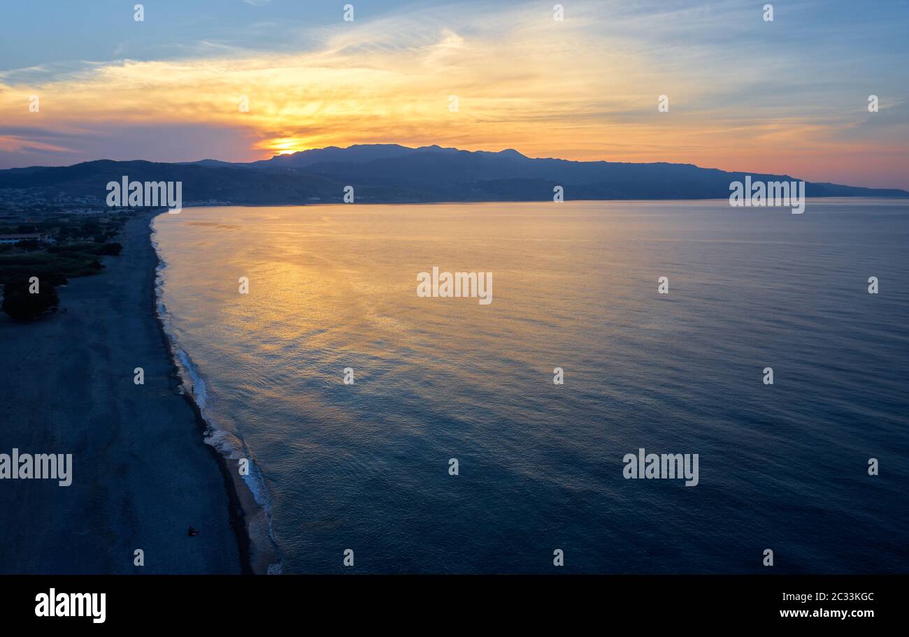 Aerial view on Platanias beachfront area, beach and sea at sunset time. Crete, Greece. Stock Photo