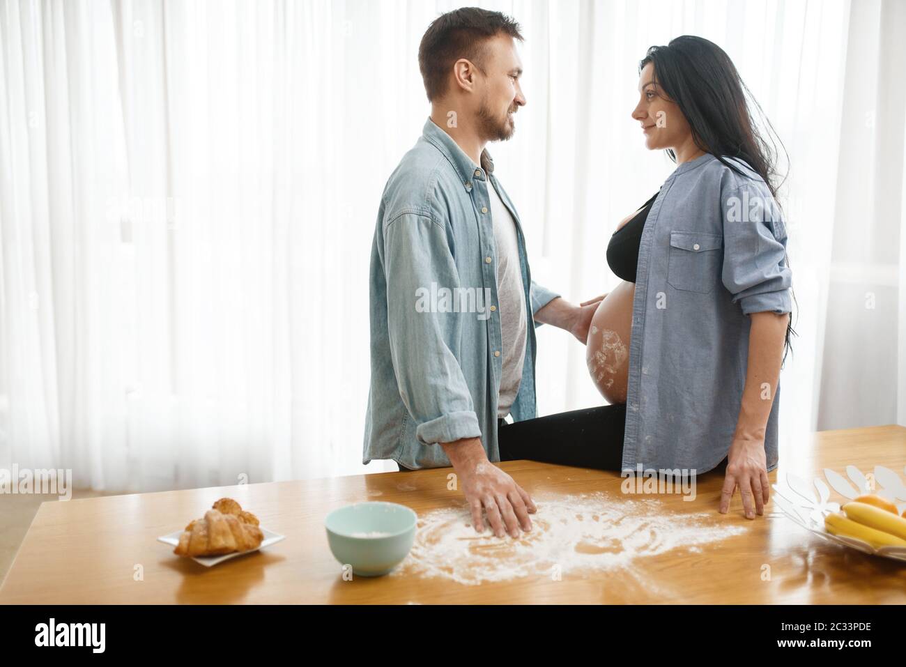 Happy Couple Caring Husband Feeding His Pregnant Wife At Home Kitchen Interior On Background Pregnancy Prenatal Period Expectant Mom And Dad Are Stock Photo Alamy