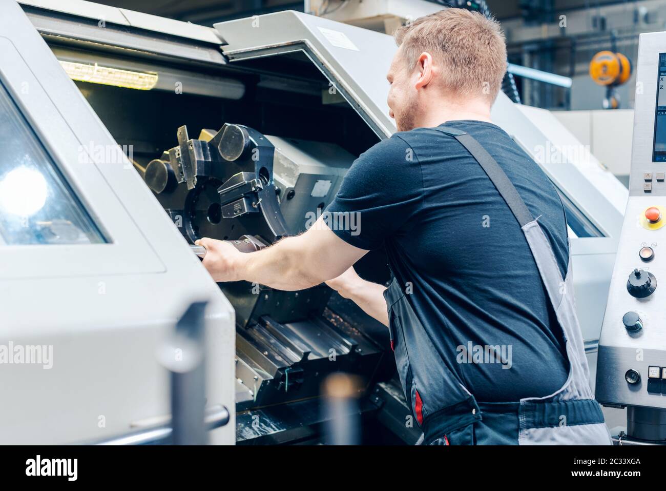 Experienced worker changing tool setup of lathe machine on the factory ...