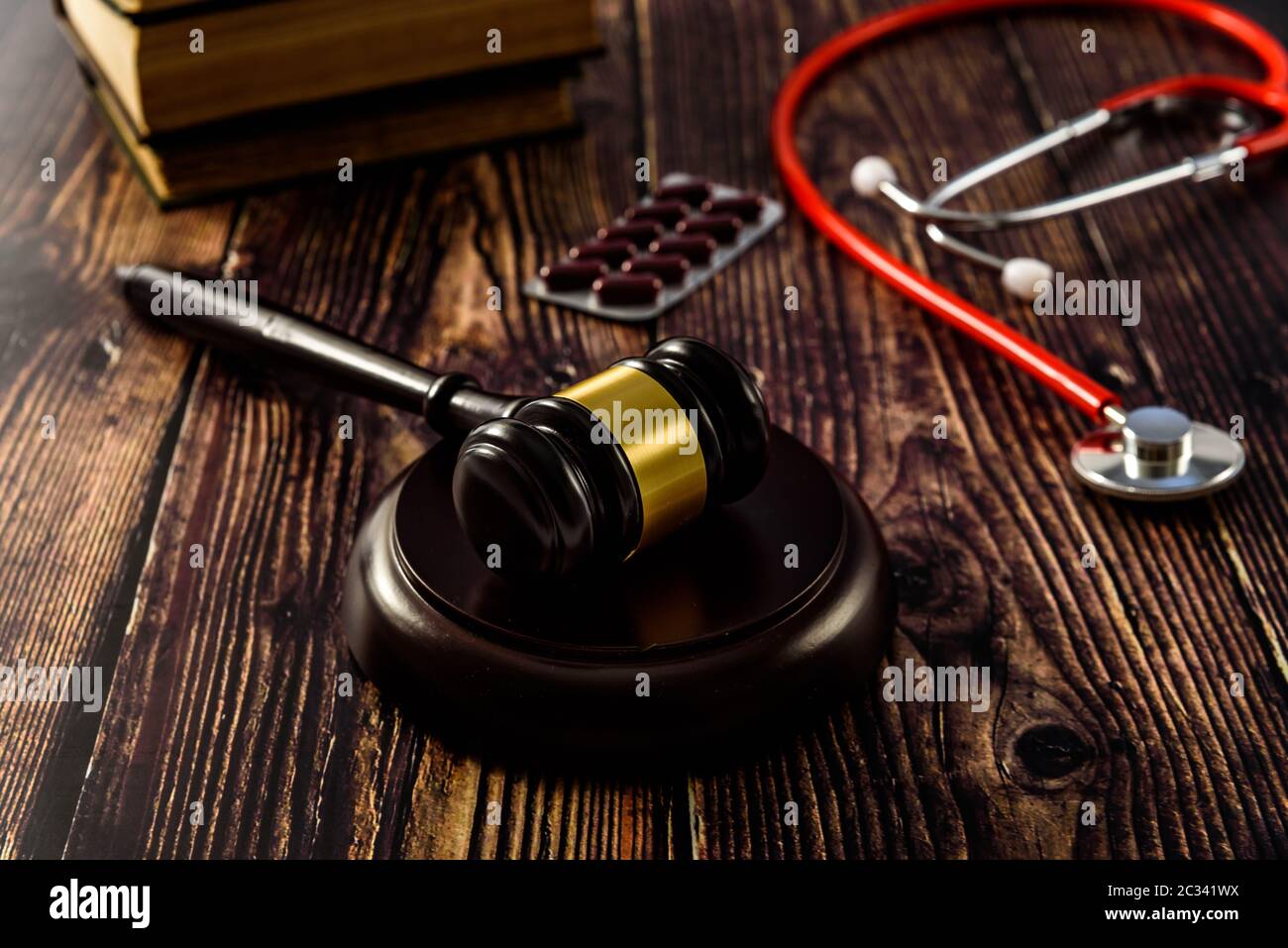 Medical malpractice and errors makes doctors and patients go to court, gavel on legal books. Stock Photo