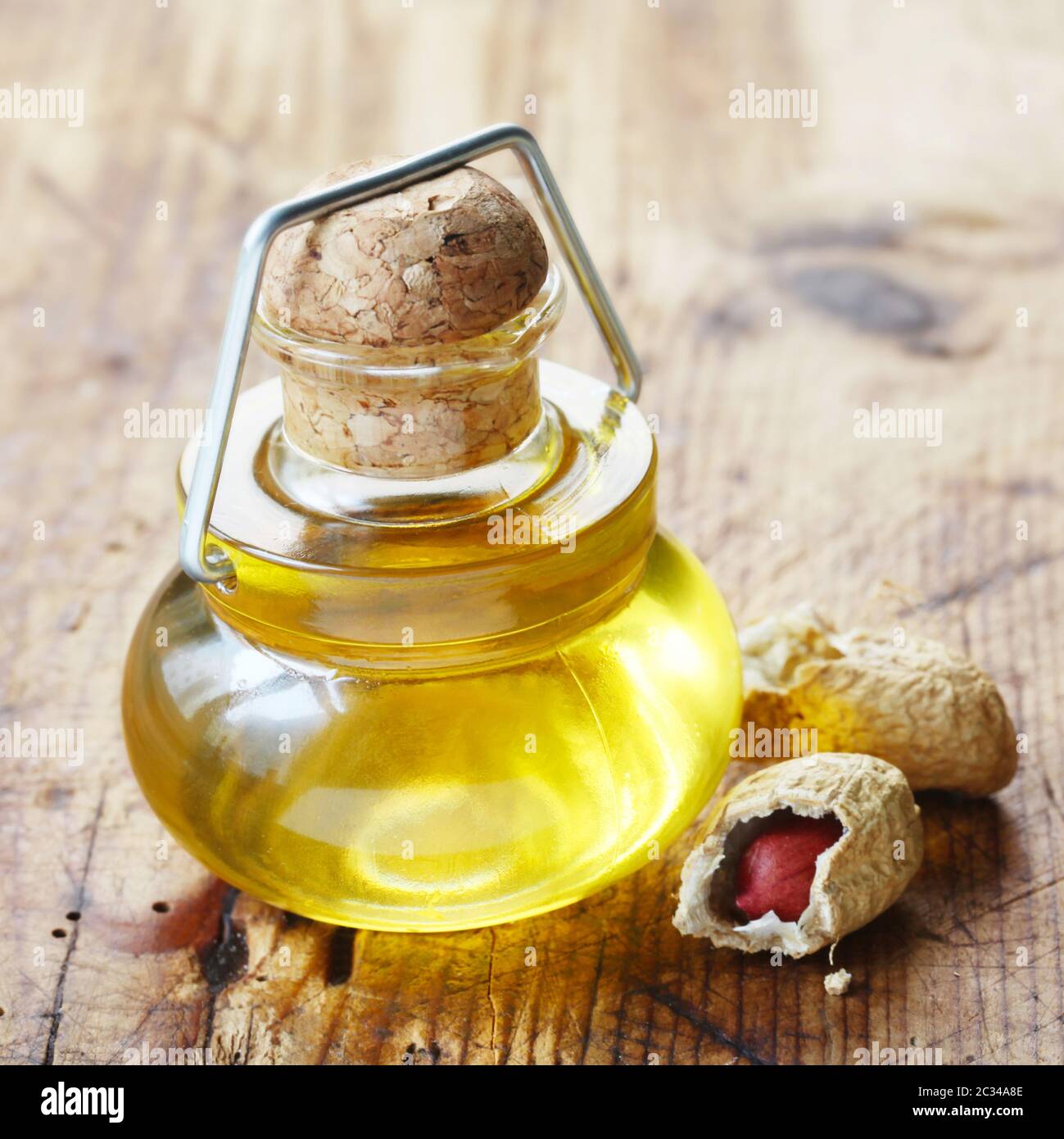 A Small Bottle Of Peanut Oil On A Wooden Background Stock Photo