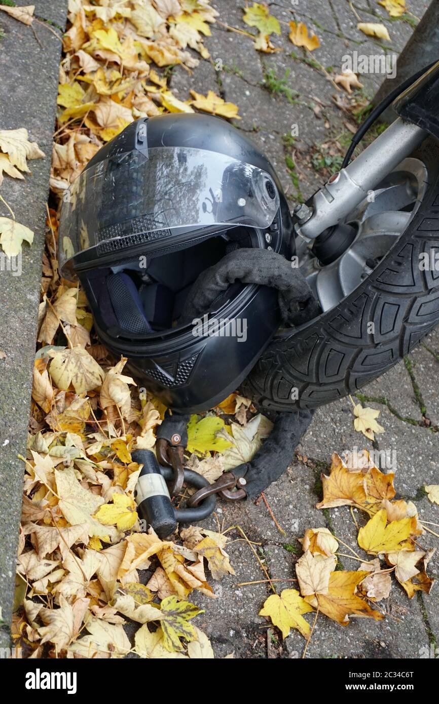 Moped in the parking lot. Fragment. Helmet is connected to wheel with a