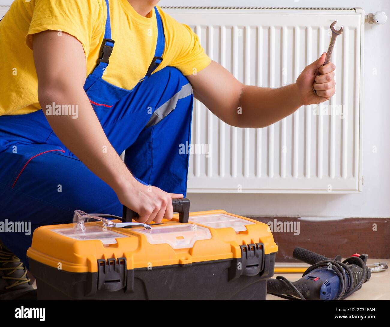 Young repairman contractor repairing heating panel Stock Photo