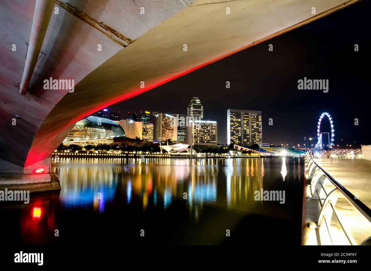 The view across the bay to the Singapore night bridge, skyscrapers and bright lights Stock Photo