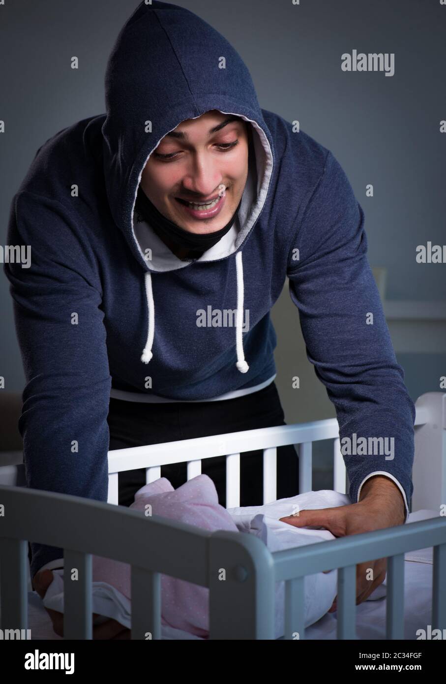 The criminal stealing baby in human child traficking concept Stock Photo