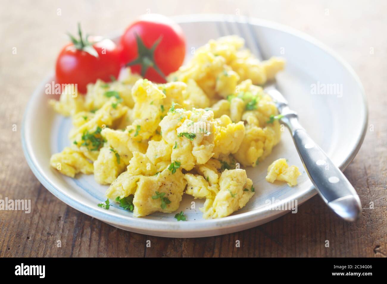 Scrambled Eggs With Tomatoes On A Plate Stock Photo