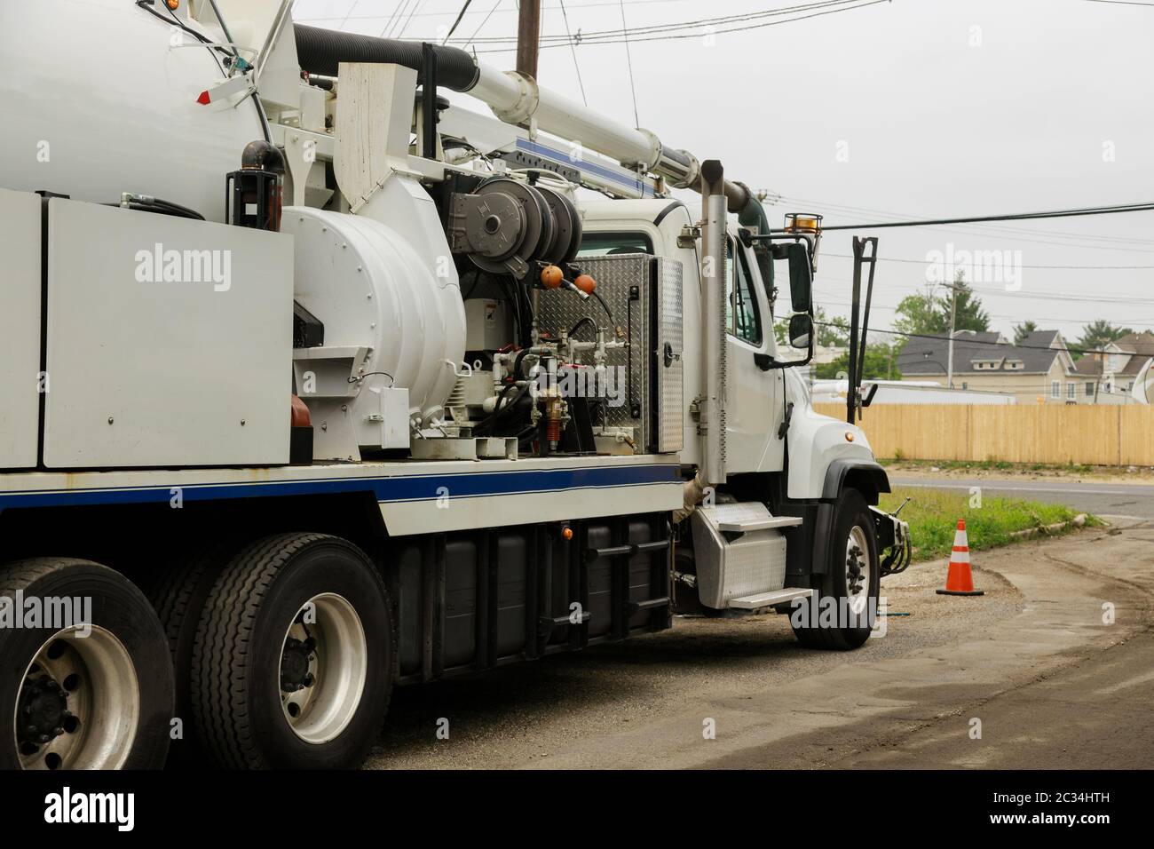 A specialized sewer cleaning machine works on a town street. Stock Photo