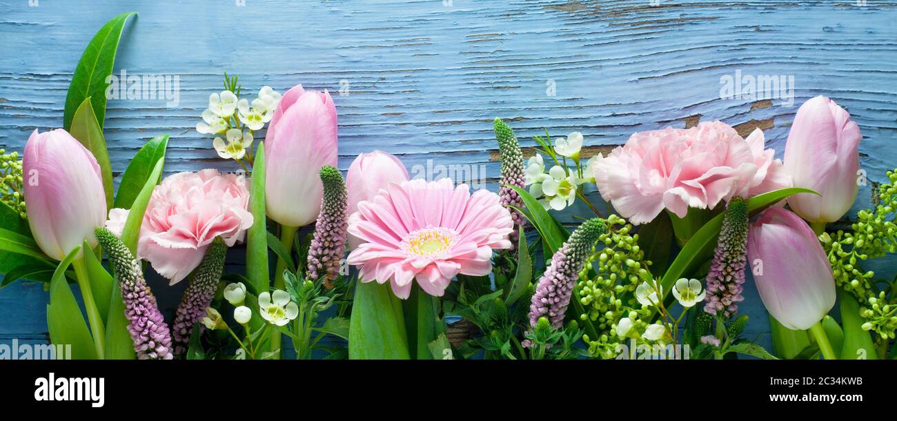 Pink Flowers On A Blue Wooden Background Stock Photo - Alamy