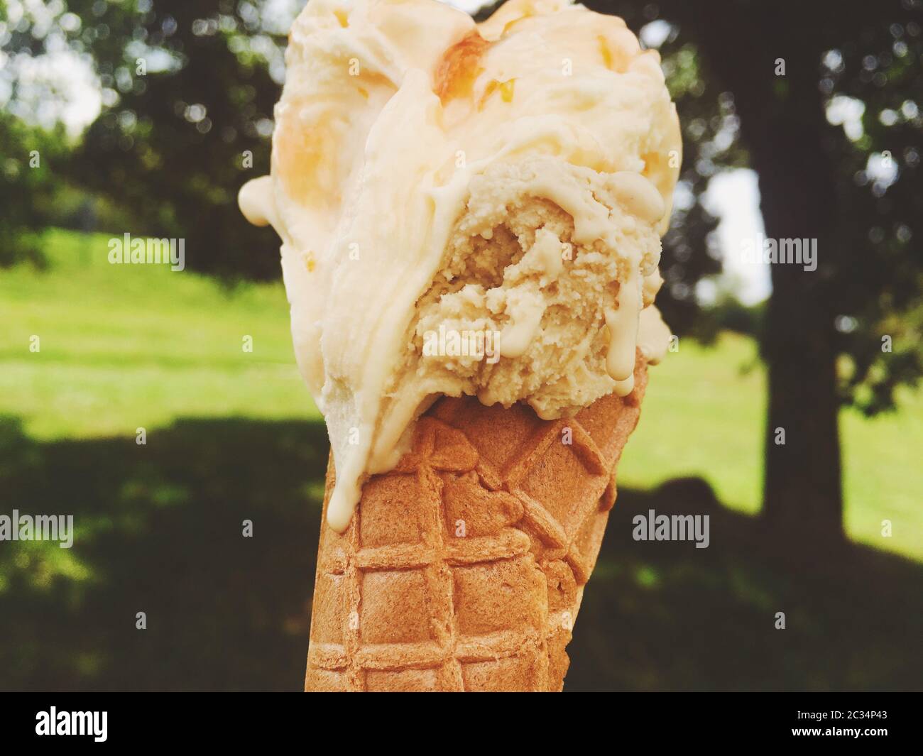 Ice cream cone melting outdoors in summer, sweet dessert food on