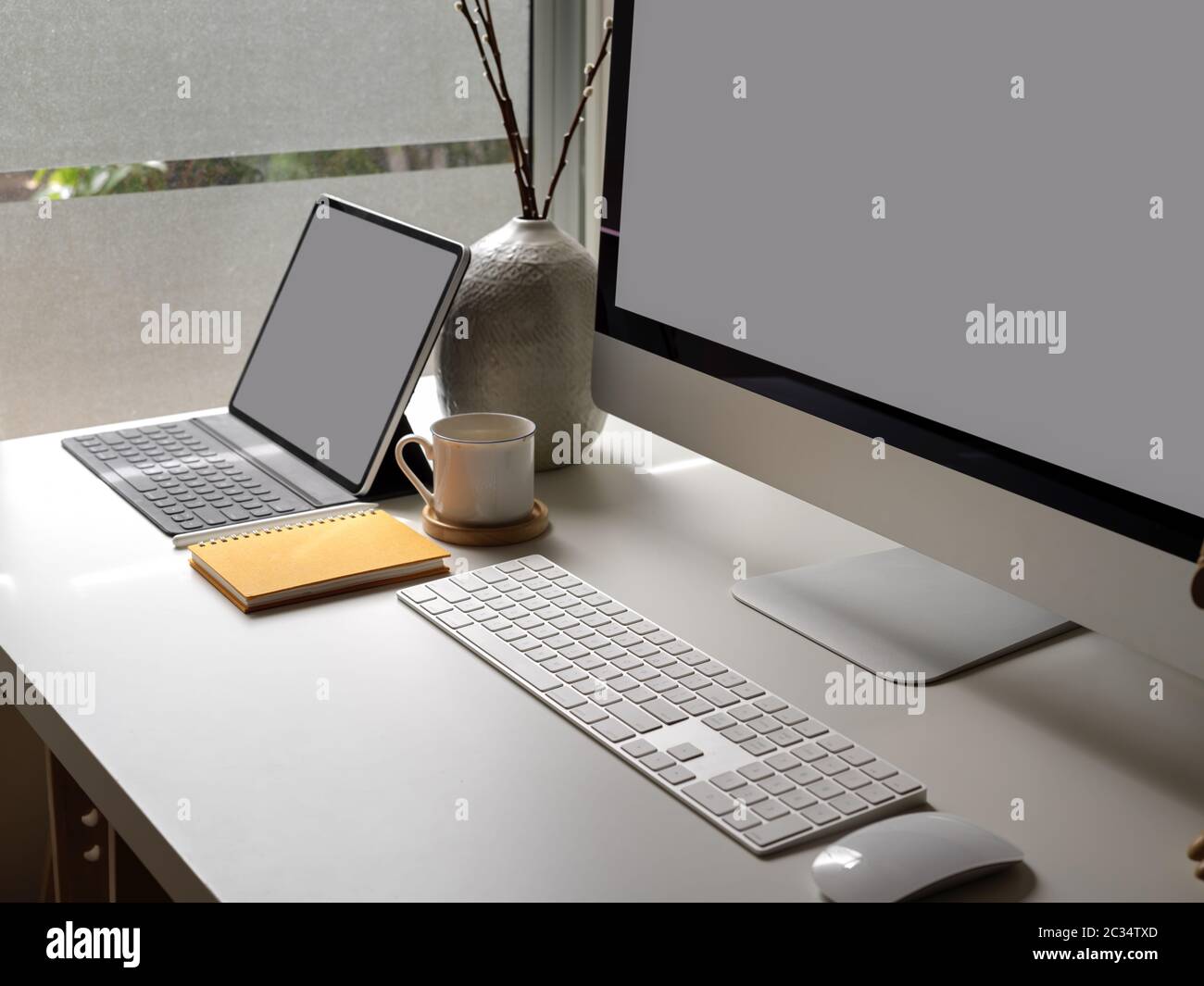 Side view of office desk with blank screen tablet, computer device