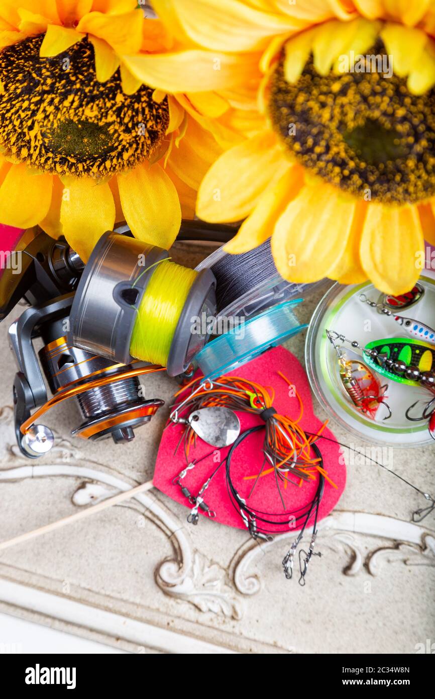 Fishing tackles, lines and reel with spring decoroation with sunflowers