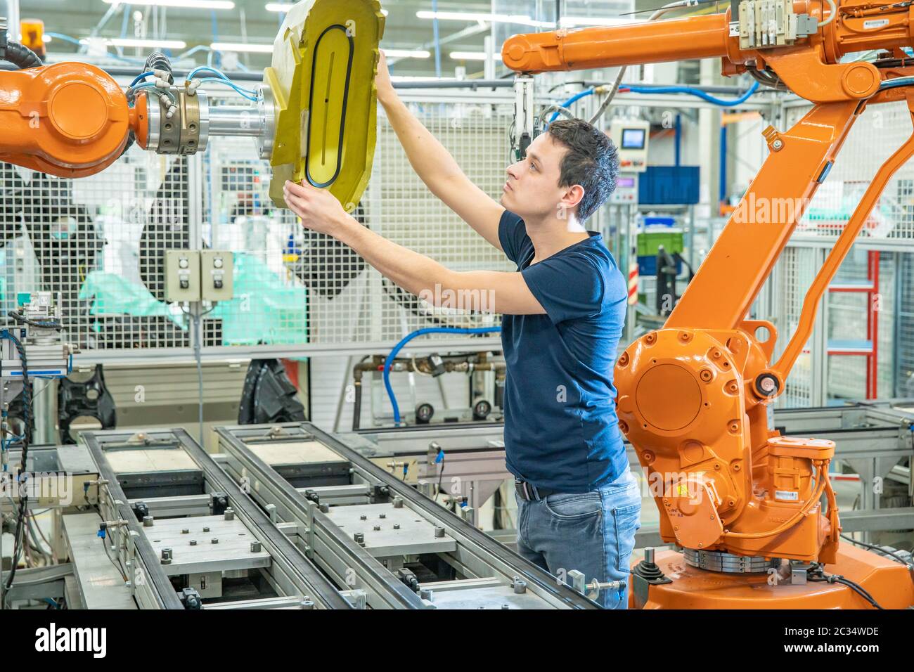 setting up a robotic line with automatic arms before starting the process. Stock Photo